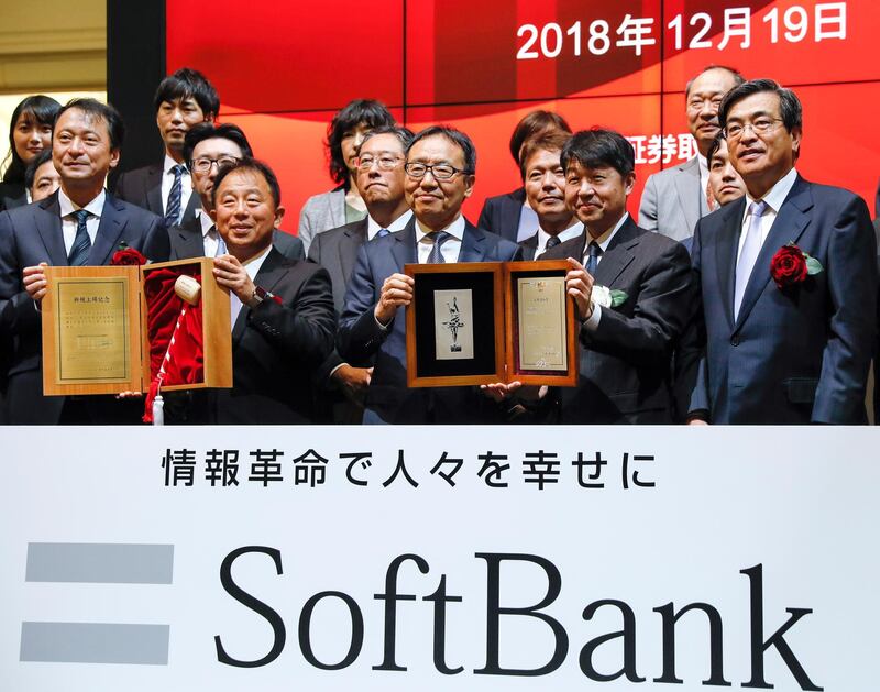 epa07239444 Ken Miyauchi (C, left), President and CEO of SoftBank Corp., SoftBank Group's mobile unit, poses for photos after a listing ceremony  marking the company's debut on the Tokyo Stock Exchange (TSE) at the TSE in Tokyo, Japan, 19 December 2018. SoftBank Corp. was listed on the Tokyo Stock Exchange on 19 December 2018 and it is the biggest initial public offering (IPO) ever in Japan.  EPA/KIMIMASA MAYAMA