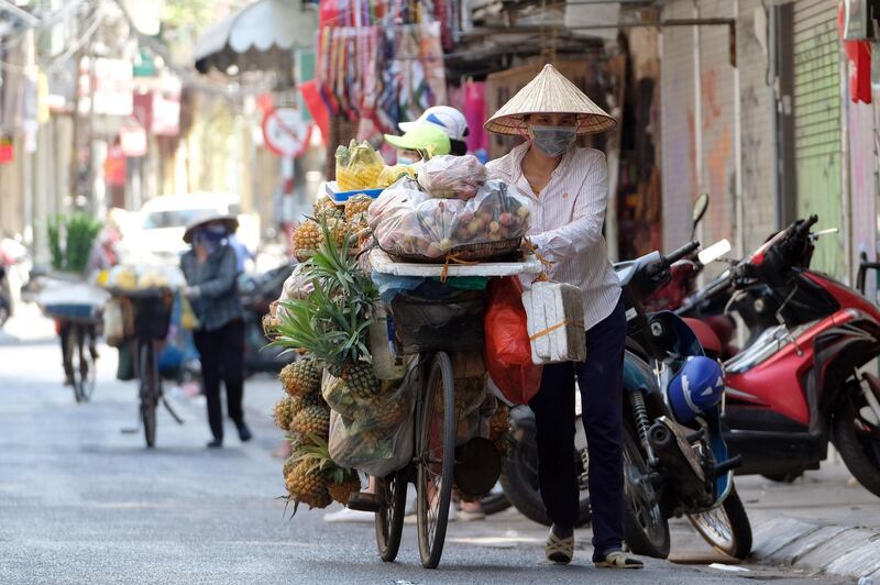 A street vendor pushes her bicycle in Hanoi, Vietnam. EPA