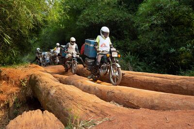 FILE PHOTO: A motorcycle convoy carrying vials of measles vaccine and other supplies for medial NGO Doctors Without Borders (MSF) crosses a log bridge on a road between Lisala and Boso-Manzi in Mongala province in the Democratic Republic of Congo February 27, 2020. Picture taken February 27, 2020. REUTERS/Hereward Holland/File Photo