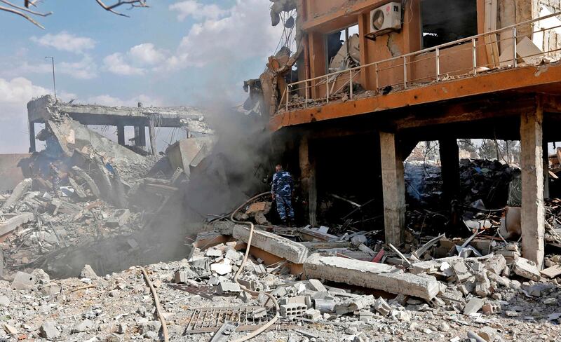 A Syrian soldier inspects the wreckage of a building described as part of the Scientific Studies and Research Centre (SSRC) compound in the Barzeh district, north of Damascus, during a press tour organised by the Syrian information ministry, on April 14, 2018.
The United States, Britain and France launched strikes against Syrian President Bashar al-Assad's regime early on April 14 in response to an alleged chemical weapons attack after mulling military action for nearly a week. Syrian state news agency SANA reported several missiles hit a research centre in Barzeh, north of Damascus, "destroying a building that included scientific labs and a training centre". AFP PHOTO / LOUAI BESHARA