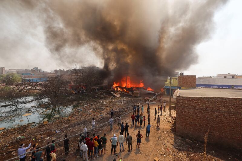 Firefighters try to douse a fire in a shop near a landfill site during a heatwave in New Delhi, India. Reuters