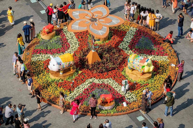 Visitors pose for photographs in front of pig figurines at the Nguyen Hue flower street, decorated for the upcoming Lunar New Year or Tet celebrations in Ho Chi Minh City. AFP