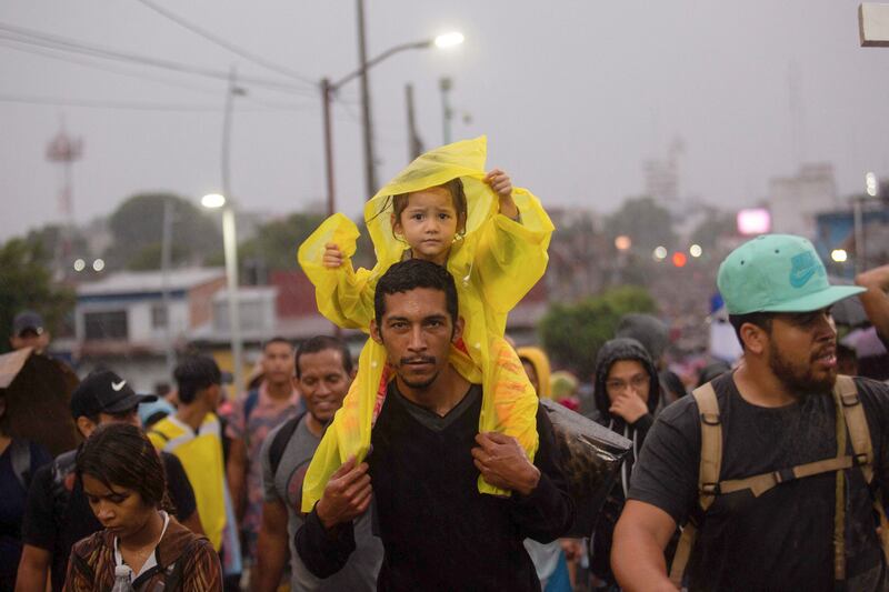 A child sits on a man's shoulders as the migrant caravan moves north in Tapachula. Reuters