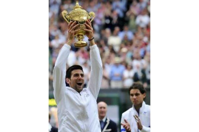 Novak Djokovic hoists the Wimbledon trophy on Sunday for the first time after beating Rafael Nadal.