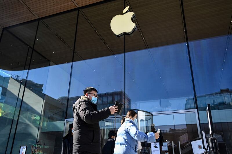 People scan health QR codes before entering an Apple store in Beijing. The company's first-quarter revenue rose 11.2 per cent a year to more than $123.9 billion. AFP