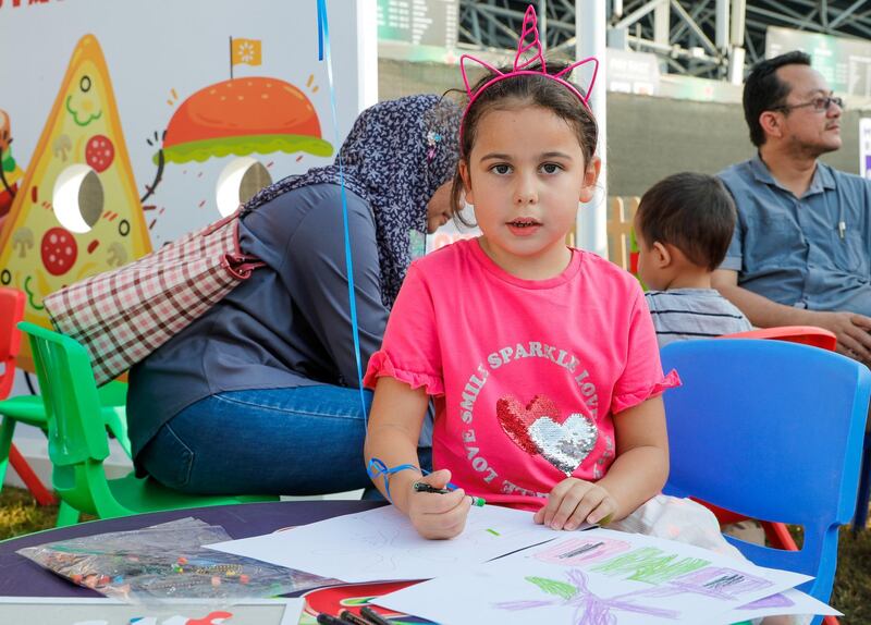 Abu Dhabi, United Arab Emirates, November 9, 2019.  
Taste of Abu Dhabi at the Du Arena.  
--Olivia Wallace bussy with her crayola drawing at the fair.
Victor Besa/The National
Section:  NA
Reporter:  '