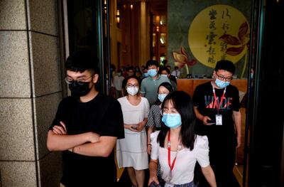 Huawei employees wearing face masks walk inside the company's headquarters in Shenzhen in China's southern Guangdong province on May 18, 2020. China on May 17 warned it would take "necessary measures" to protect Huawei and other firms after the United States announced new restrictions on the tech giant's purchases of semiconductor technology. / AFP / NOEL CELIS
