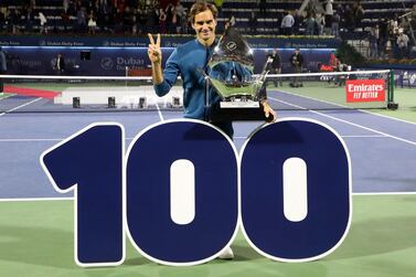 TOPSHOT - Switzerland's Roger Federer celebrates with the trophy after winning the final match at the ATP Dubai Tennis Championship in the Gulf emirate of Dubai on March 2, 2019. Roger Federer won his 100th career title when he defeated Greece's Stefanos Tsitsipas 6-4, 6-4 in the final of the Dubai Championships. / AFP / KARIM SAHIB