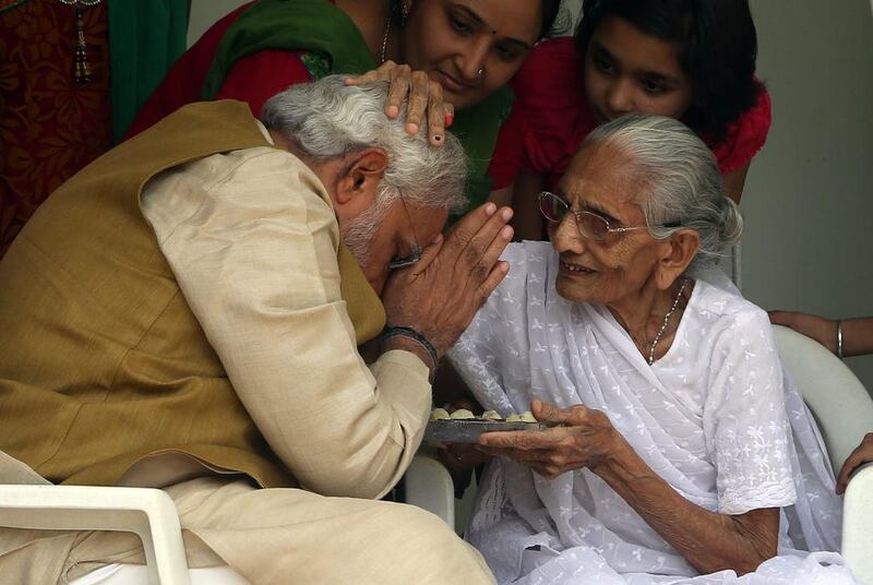 Narendra Modi takes blessings from his mother Hiraba at his brothers residence in Gandhinagar, India. As a child,  Mr Modi would often help his father serve tea on a suburban train station platform. EPA / May 16, 2014