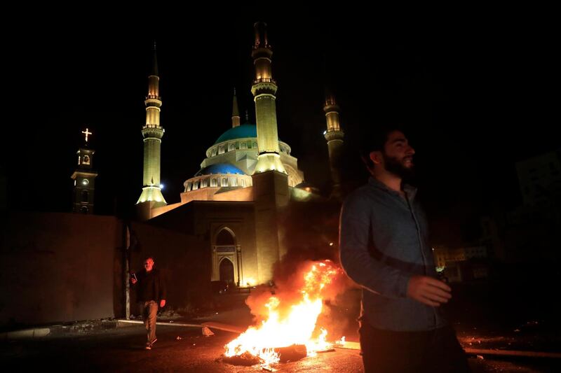 Protesters block a main road by burning tires, after a top court suspended a Central Bank decree that allowed the Lebanese to withdraw from dollar deposits at a rate two and a half times better than the fixed exchange rate, in downtown Beirut, Lebanon, early Thursday, June 3, 2021. In a late night burst of anger, dozens of protesters blocked main roads in Beirut and north of the capital to protest against the constant humiliation of Lebanese who line up to fill their cars with fuel, increasing power cuts, search for medicine and deal with confused banking decisions that are robbing thousands of their savings. (AP Photo/Hussein Malla)