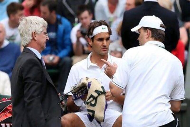 Roger Federer required some physio to overcome a balky back issue but eventually defeated Xavier Malisse.