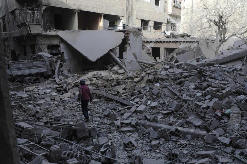 TOPSHOT - A Syrian boy walk past destruction following government air strikes in the Eastern Ghouta rebel-held enclave of Douma, on the eastern outskirts of the capital Damascus on March 19, 2018.
At least 20 civilians have died in a resumption of bombing on Douma, the largest town in shrinking rebel-controlled pockets of Syria's Eastern Ghouta, a monitor said. The fresh bloodshed came after a week-long lull in the bombardment of Douma after negotiations between rebels and regime-backer Russia allowed medical evacuations from the town. / AFP PHOTO / HAMZA AL-AJWEH