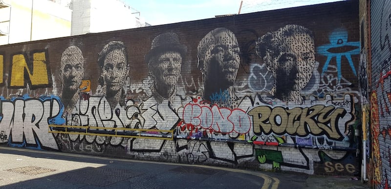 A portrait mural and graffiti in Shoreditch. Photo by Rosemary Behan