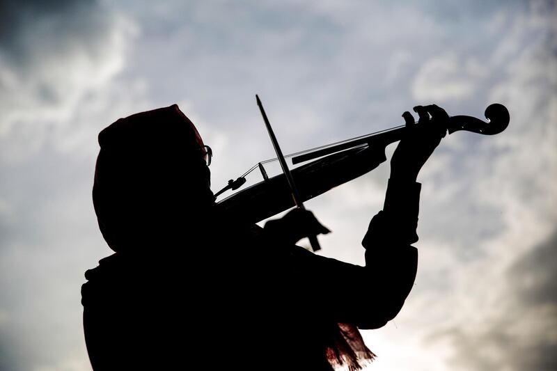 In this photo taken on Sunday, April 8, 2018, a silhouette of a Yemeni female music student practices playing the violin during a music class at the Cultural Centre in Sanaa, Yemen. For the young people who receive lessons from Abdullah El-Deb'y, music is a safe haven from the misery of Yemenâ€™s devastating war. El-Debâ€™y offers free lessons to students eager to escape the suffering caused by the war and is seeking to form a national orchestra comprised of young Yemenis.(AP Photo/Hani Mohammed)