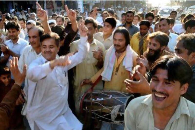 Pakistani people dance as they celebrate a Supreme Court's decision to disqualify former Prime Minister Yusuf Raza Gilani.