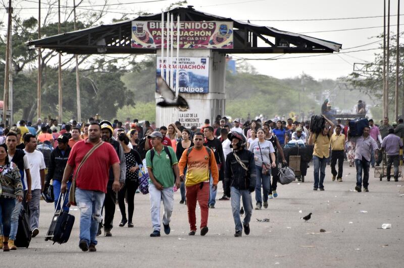 PARAGUACHON, COLOMBIA - JUNE 08: Venezuelans walk crossing the border from Venezuela to Colombia on June 8, 2019 in Paraguachon, Colombia. Today United Nations High Commissioner for Refugees (UNCHR) Special Envoy Angelina Jolie and Deputy High Commissioner Kelly Clements will visit the UNHCR refugee camp of Maicao, located 8km west of the border west border between Colombia and Venezuela, a key point for migrants to cross. UN and International Organization for Migration (IOM) announced yesterday that 4 million of Venezuelans have left their country since 2015 due to the social, political and economic crisis, which means they are of the single largest population groups displaced from their country globally. The camp in Maicao has 60 tents  which can accommodate up to 350 people. Due to high demand, UNHCR is considering an expansion to give shelter to 1,400 people. Colombia it the top host of Venezuelan migrants and refugees, accounting 1.3 million. (Photo by Guillermo Legaria/Getty Images)