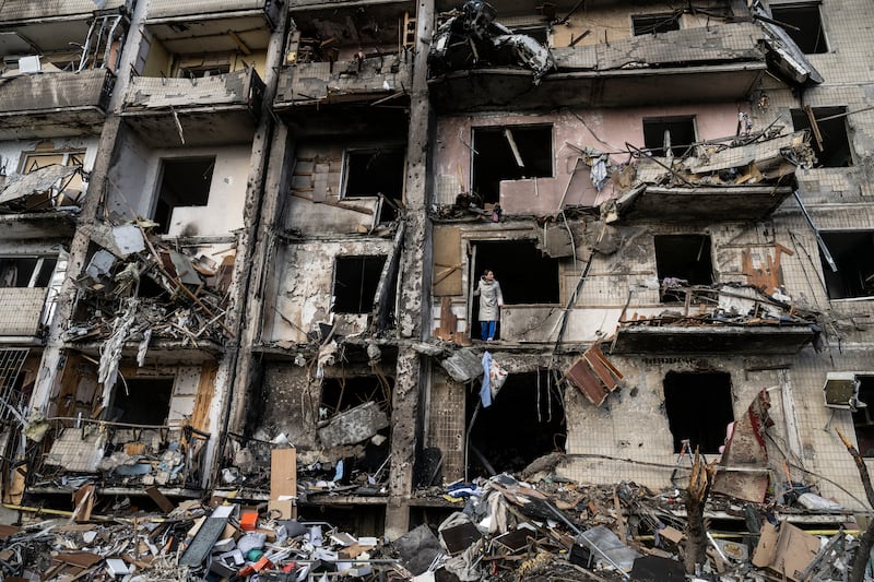 Ukrainians clean up debris after a residential building was hit by Russian missiles in southern Kyiv, in February 2022.