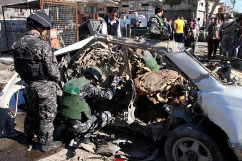 Iraqi policemen examine the remains of a car bomb in Sadr City. Qahtan Al Sudani / Reuters