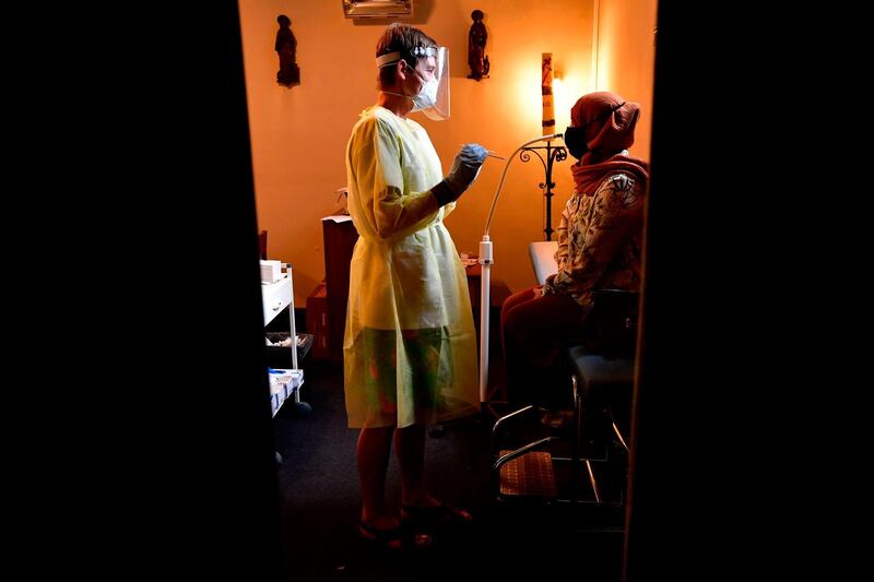 A nurse prepares to take a nasal swab test on a woman in Antwerp, Belgium. AFP