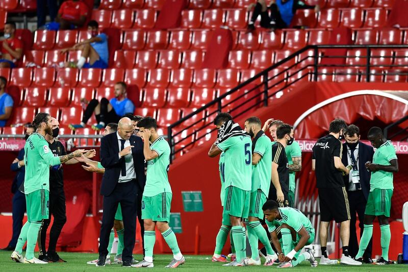 Real Madrid mmanager Zinedine Zidane, centre left, talks with Marco Asensio during the game against Granada. AP Photo