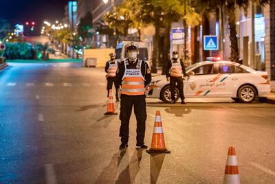 Moroccan police officers man a checkpoint during night curfew as a precaution against the novel coronavirus (COVID-19) in the country's capital Rabat, early on May 2, 2020. / AFP / FADEL SENNA
