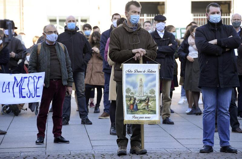 A catholic worshipper holds a sign reading 'Our Lady of Fatima, pray for us' as he takes part with others in a rally in Strasbourg, eastern France, held to protest against a ban on the celebration of masses because of the coronavirus restrictions.  AFP