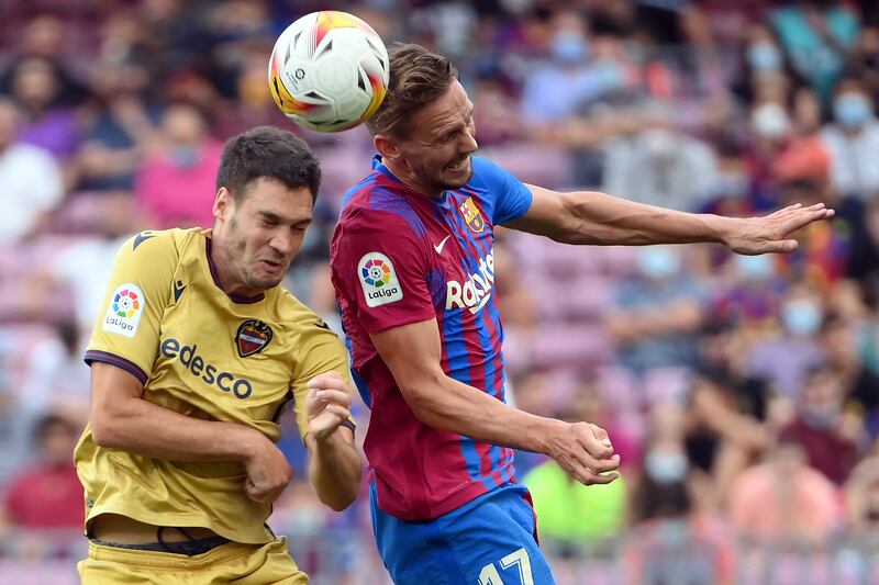 Levante's Montenegrin midfielder Nikola Vukcevic vies for a header with Barcelona's Dutch forward Luuk de Jong. AFP