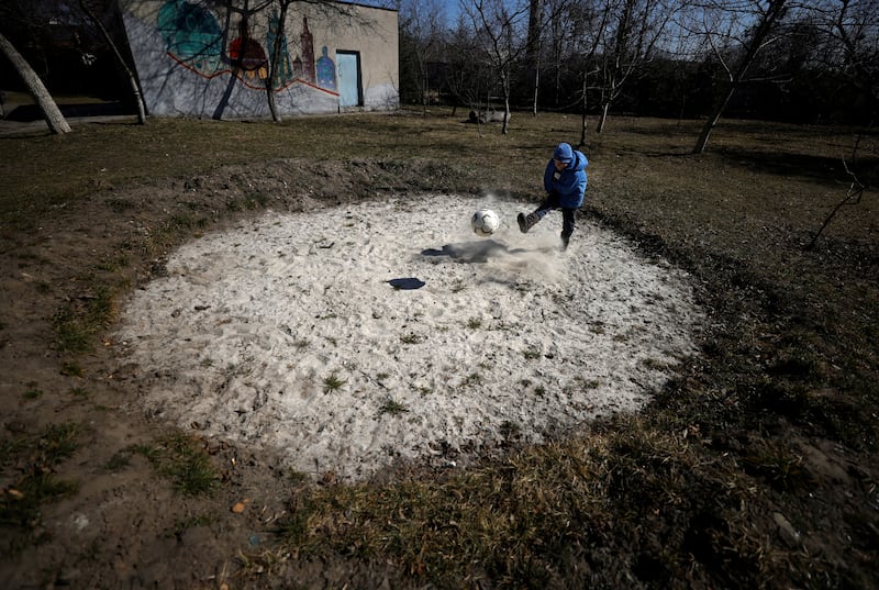 Mykhaylo, 8, who was taken away from his widowed mother along with his 9-year-old brother and 16-year-old sister, plays with a ball in the garden of a state shelter in Lviv. Reuters