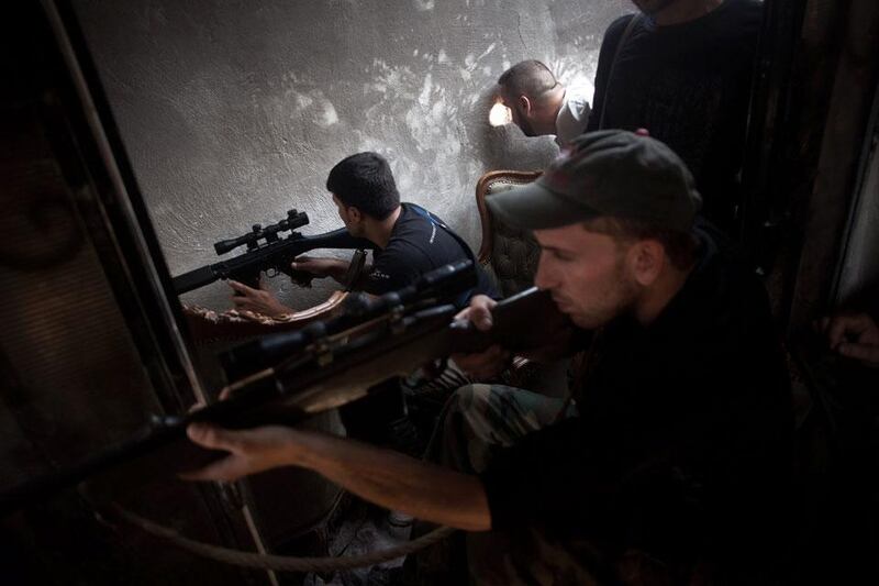 Rebel soldiers scan for targets from within a bombed building in the Saif Al Dula district.  Manu Brabo / AP Photo
