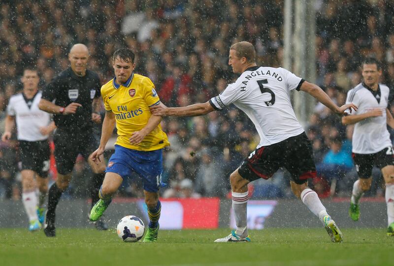Arsenal's Aaron Ramsey, center left, competes with Fulham's Brede Hangeland during their English Premier League soccer match at Craven Cottage, London, Saturday, Aug. 24, 2013. (AP Photo/Sang Tan) *** Local Caption ***  Britain Soccer Premier League.JPEG-0734c.jpg