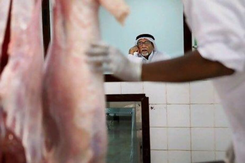 Customers wait at the counter for the meat from slaughtered animals at the public abattoir in Al Ain.