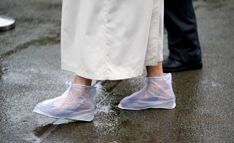 A racegoer wears rain covers on her feet as she arrives for day four of Royal Ascot at Ascot Racecourse. Andrew Matthews/PA Wire.
