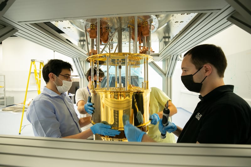 The institute’s Quantum Research Centre team opens the outer shields of the refrigerator housing the machine to reveal the chandelier. The device enables the temperature to be lowered in stages.