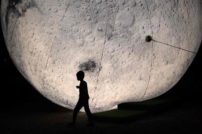 A child walks past a large moon-shape lantern on the waterfront in Wellington, New Zealand. AFP