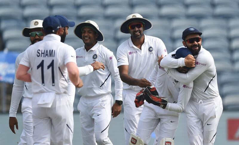 Indian Virat Kohli, right, celebrates with wicketkeeper Wriddhiman Saha following the dismissal of South Africa batsman Theunis de Bruyn in Pune. AFP