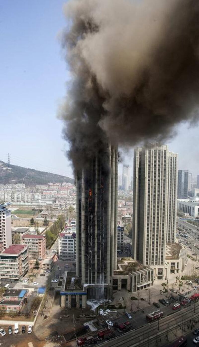Smoke rises from a residential building as firefighters attempt to extinguish a fire, in Dalian, Liaoning proving. The fire broke out from the exterior of the building and was put out after half an hour. China Daily / Reuters