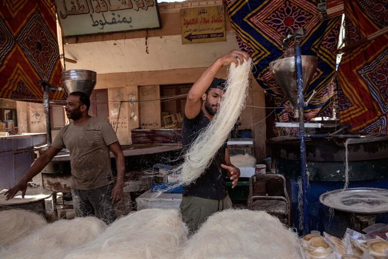 28-year-old football defender Mahrous Mahmoud, right, makes Ramadan sweets, in Manfalut, a town 350 kilometres south of Cairo in the province of Assiut, Egypt. AP Photo