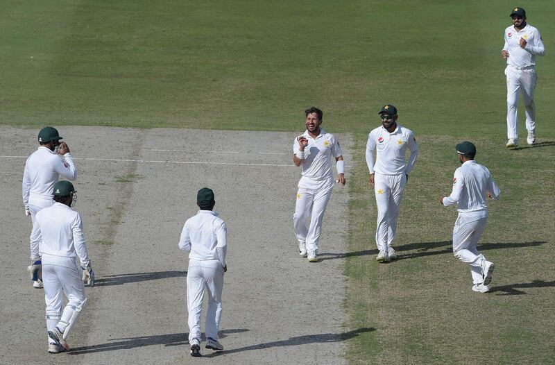 Pakistani spinner Yasir Shah (C) celebrates with teammates after taking the wicket of New Zealand batsman Ish Sodhi during the fourth day of the second Test cricket match between Pakistan and New Zealand at the Dubai International Stadium in Dubai on November 27, 2018. / AFP / AAMIR QURESHI
