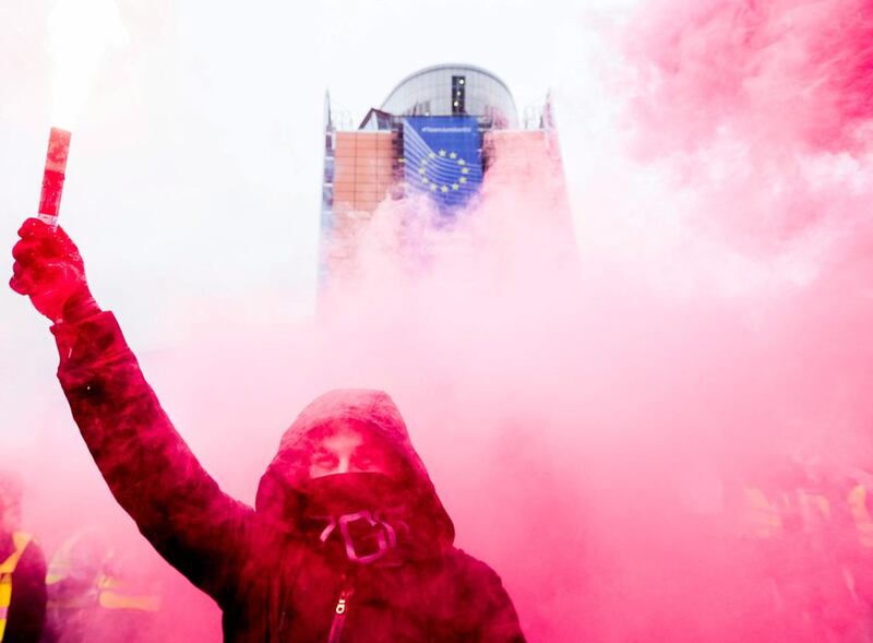 A protester lights a flare in Brussels, Belgium, as he takes part in an European steel workers protest against China flooding the market with lower-priced steel. Stephanie Lecocq / EPA