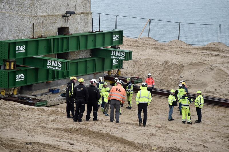 Workers prepare the Rubjerg Knude Lighthouse to be moved on rails in Jutland, Denmark.  EPA