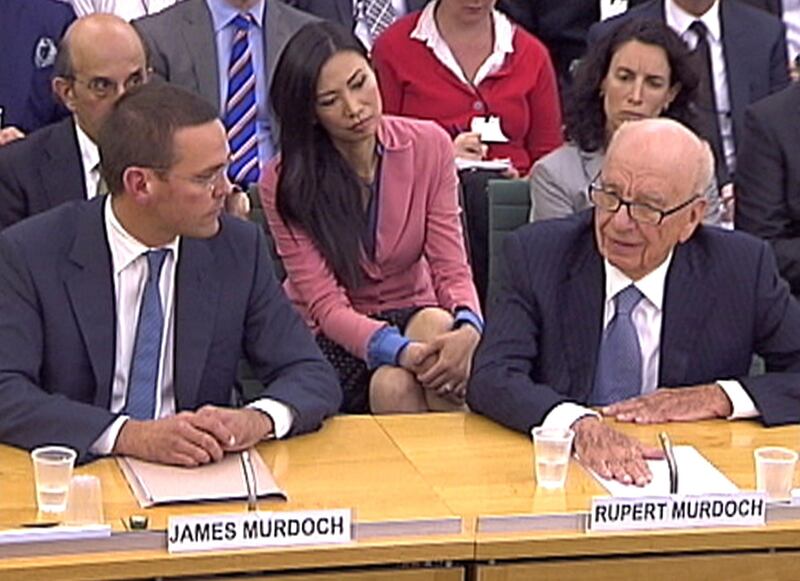 Rupert Murdoch's wife Wendi Deng (C) looks on as BSkyB Chairman James Murdoch and News Corp Chief Executive and Chairman Rupert Murdoch (R) appear before a parliamentary committee on phone hacking at Portcullis House in London July 19, 2011. Rupert Murdoch told the British parliament on Tuesday that giving evidence on the phone-hacking and corruption scandal that is engulfing his global media empire was "the most humble day of my life".  REUTERS/Parbul TV via Reuters Tv (BRITAIN - Tags: CRIME LAW MEDIA) FOR EDITORIAL USE ONLY. NOT FOR SALE FOR MARKETING OR ADVERTISING CAMPAIGNS *** Local Caption ***  CLH138_NEWSCORP-_0719_11.JPG