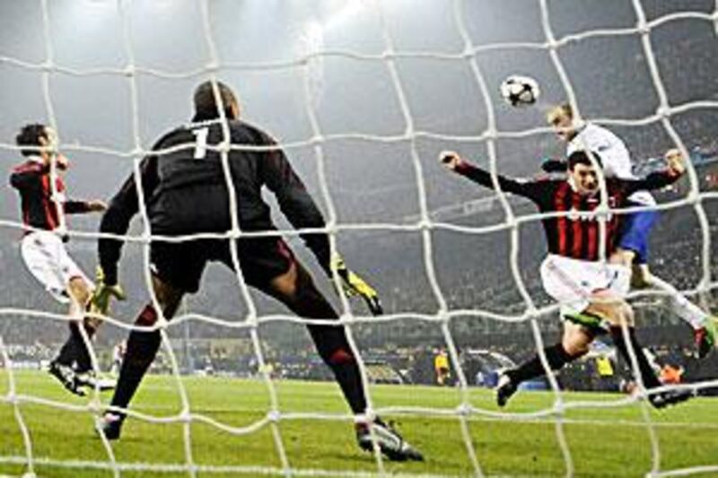Manchester United's Wayne Rooney scores his first header against AC Milan at the San Siro on Tuesday night in front of 78,000 fans.