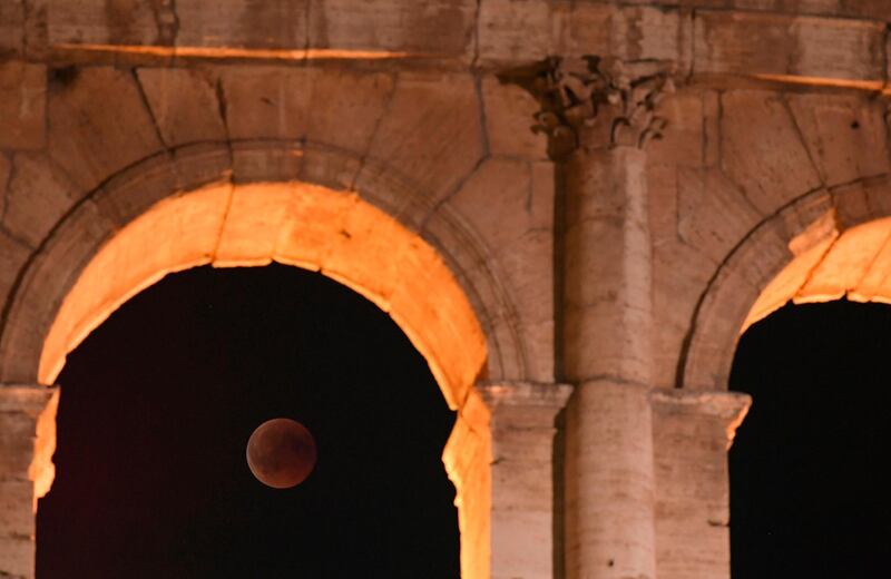The full moon during a 'blood moon' eclipse behind the ancient Colosseum in Rome, Italy. AFP