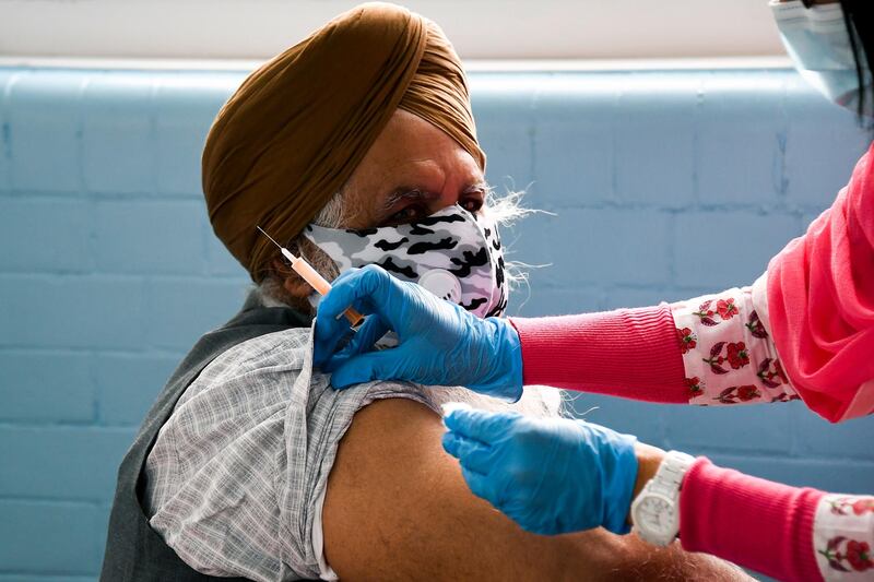 Dr Kuldip Sule administers a dose of the AstraZeneca vaccine at the Guru Nanak Gurdwara Sikh temple, in Luton. AP Photo