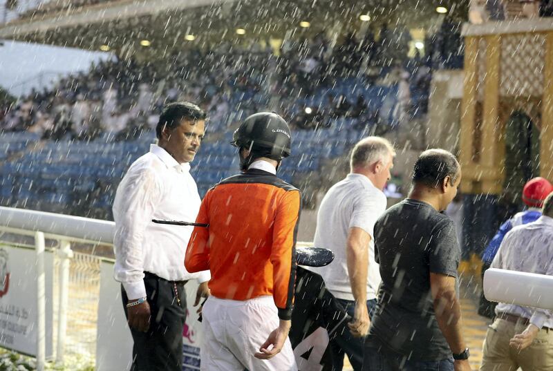 ABU DHABI , UNITED ARAB EMIRATES , November 25  ��� 2018 :- Officials and jockeys during the rain at the Abu Dhabi Equestrian Club in Abu Dhabi. ( Pawan Singh / The National ) For News/Instagram 