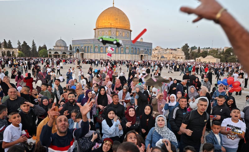 Muslims receive gifts in front of the Dome of the Rock mosque after the morning Eid al-Fitr prayer, which marks the end of the holy fasting month of Ramadan, at the Al-Aqsa mosques compound in Old Jerusalem. AFP