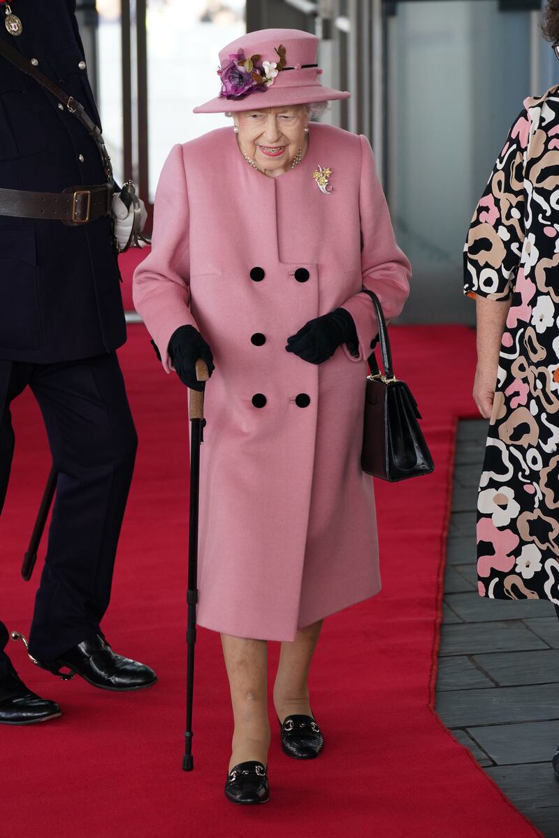 Queen Elizabeth II, wearing pink, arrives for the opening ceremony of the sixth session of the Senedd at The Senedd on October 14, 2021 in Cardiff. Getty Images