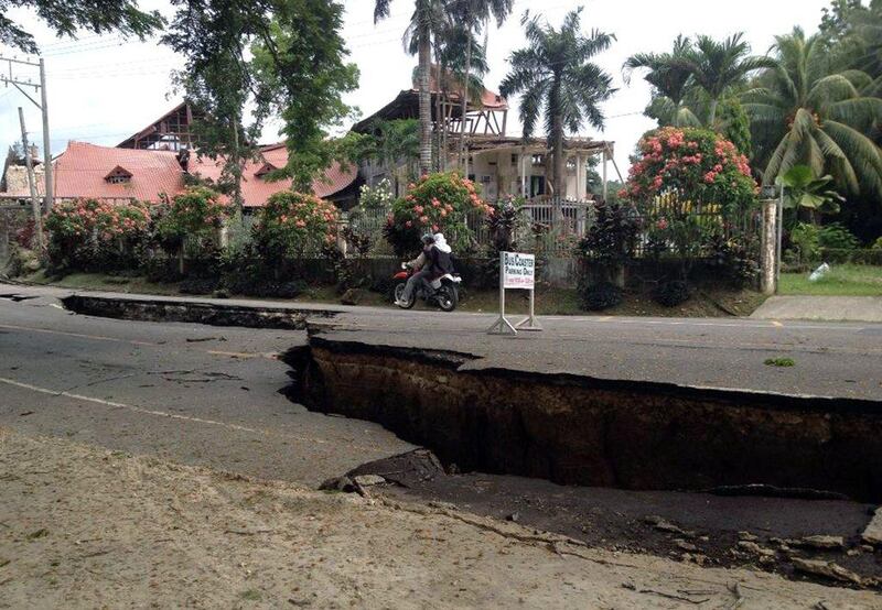 A couple on a motorbike ride on a damaged road in the Philippine town of Loboc, Bohol after a major 7.1 magnitude earthquake struck the region AFP Photo / Robert Michael Poole

