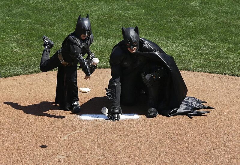 Miles Scott, dressed as Batkid, left, throws the ceremonial first pitch next to Batman before the San Francisco Giants play the Arizona Diamondbacks. Jeff Chiu / AP