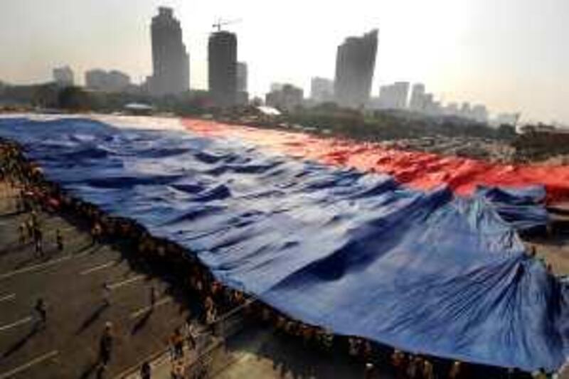 Supporters of Philippine religious leader and presidential candidate Eddie Villanueva unfurl a huge national flag to signal the start of his campaign at Luneta, in Manila, on February 9, 2010.  The Philippine election season kicked off with the world's best boxer and the defiant wife of a dead dictator among the dizzying array of characters hoping to grab a share of power.  The Southeast Asian nation's chaotic brand of democracy will see 50 million voters choose a new president and thousands of lower positions on May 10, but observers warned candidates' promises of change were likely to prove hollow.   AFP PHOTO/NOEL CELIS *** Local Caption ***  808185-01-08.jpg *** Local Caption ***  808185-01-08.jpg